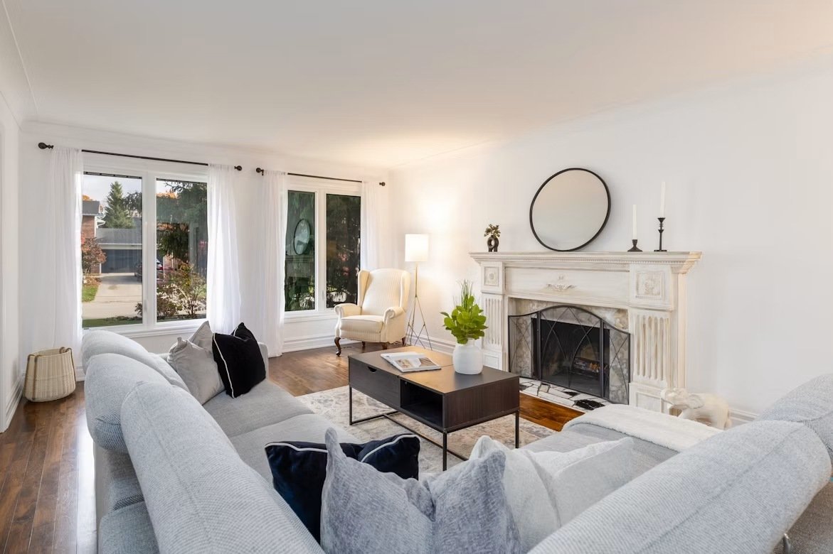 A bright neutral living room arranged around a fireplace